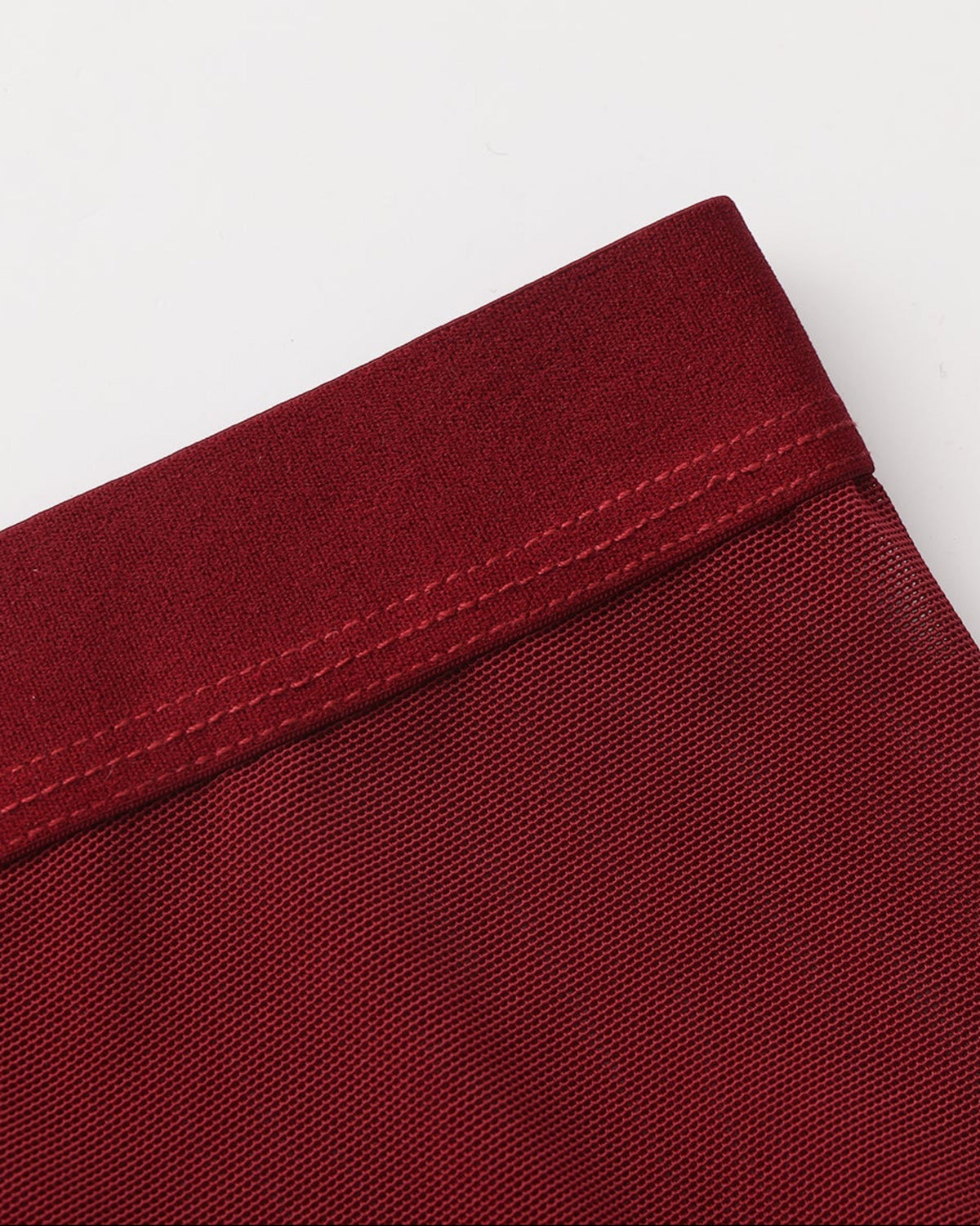 Close-up of the deep red BSZN trunk waistband binding and fine mesh