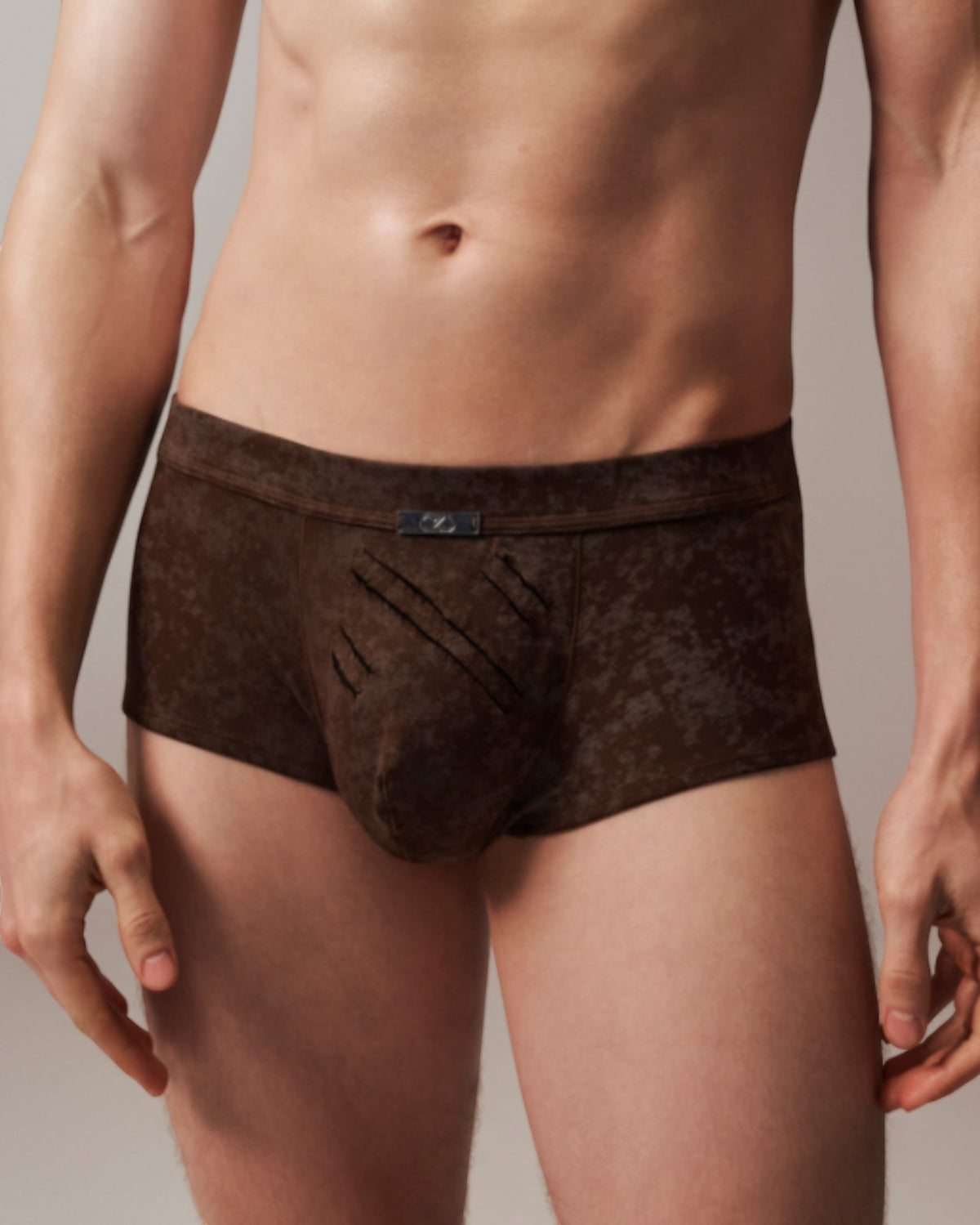 Model wearing the mottled brown BSZN Eternal Trace Slash-Cut Trunk, front view