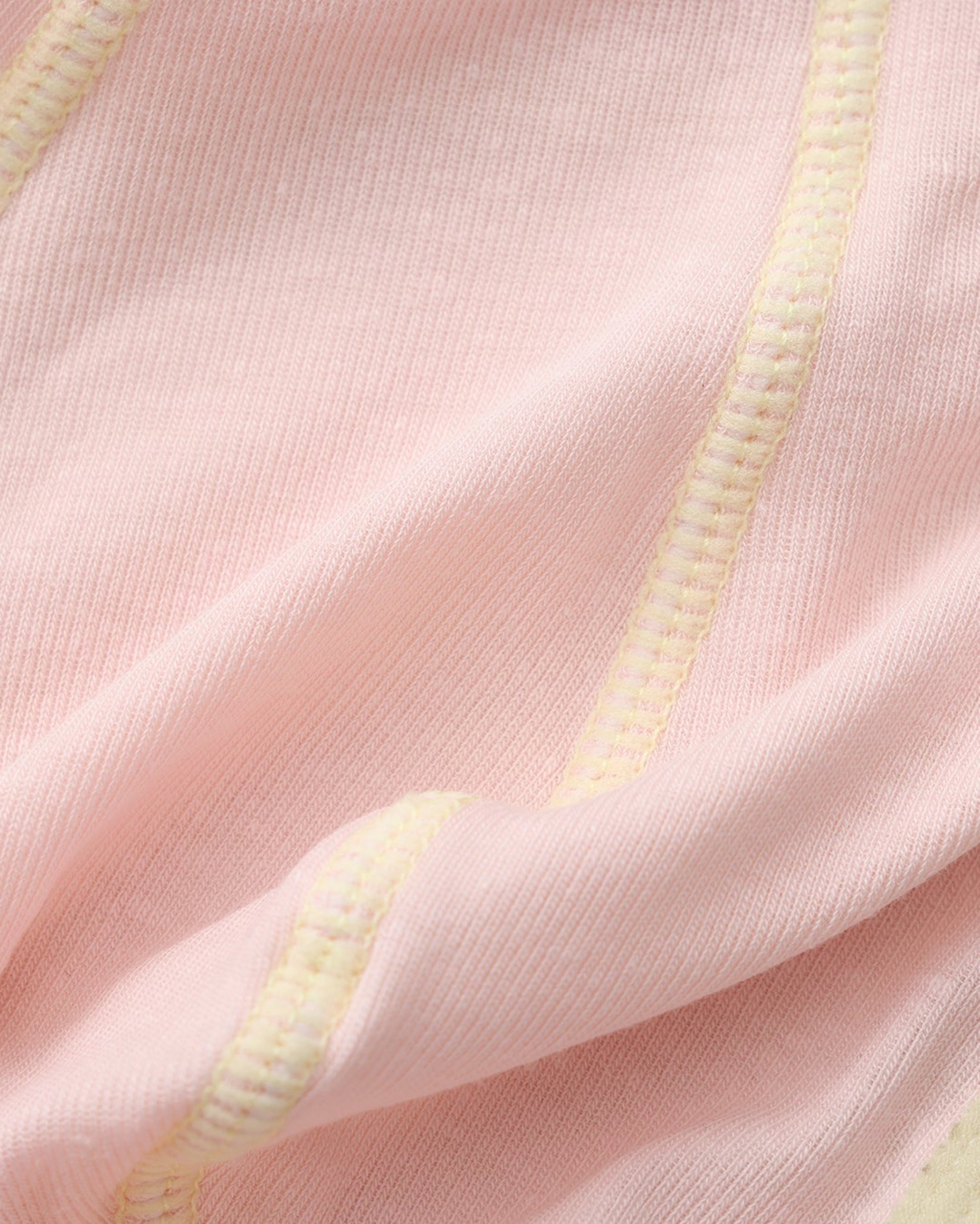 Close-up of the fine pink knit and contrast overlock seam