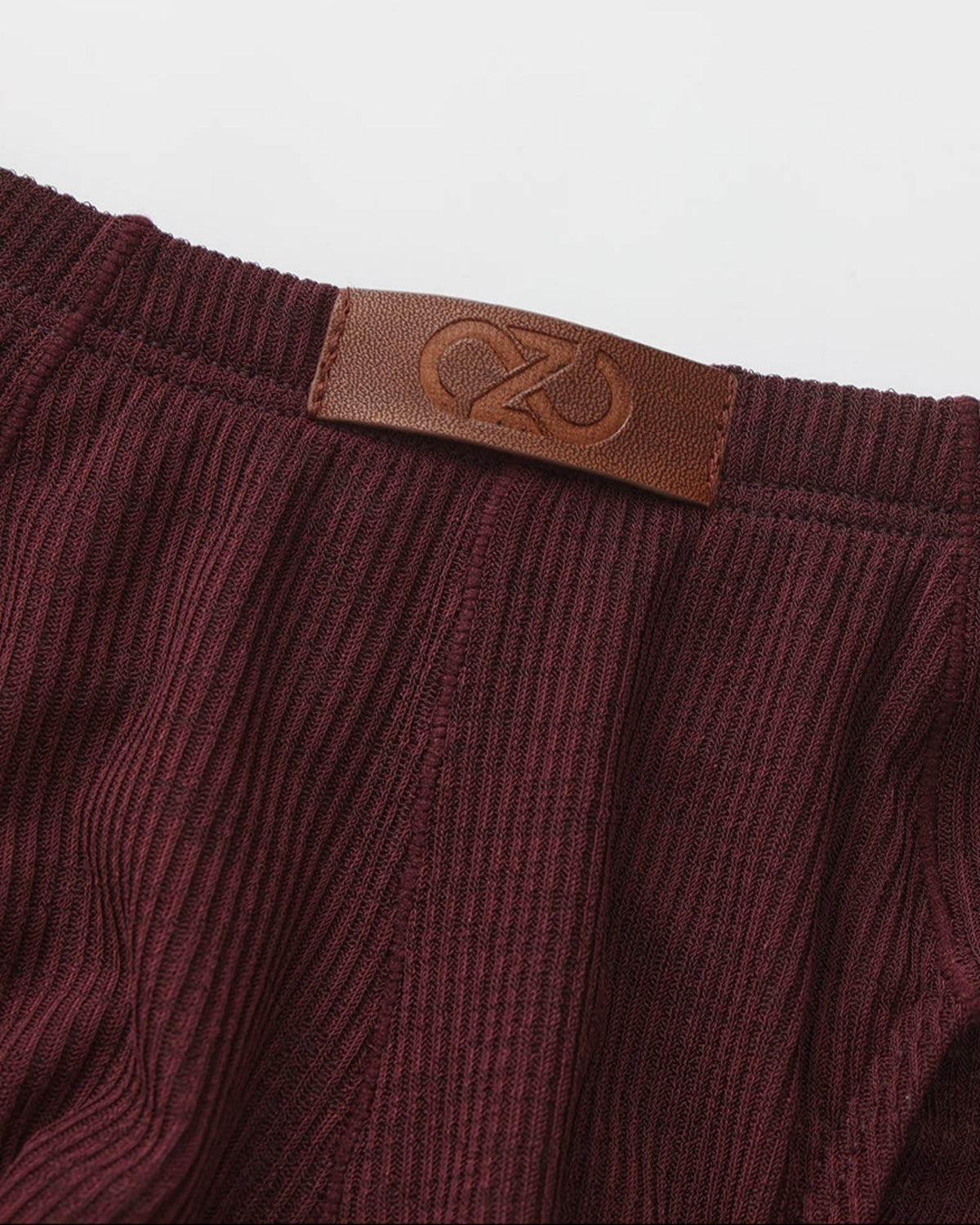 BSZN Crystal Veil V-Sculpt Brief — Dark red logo patch close-up.
