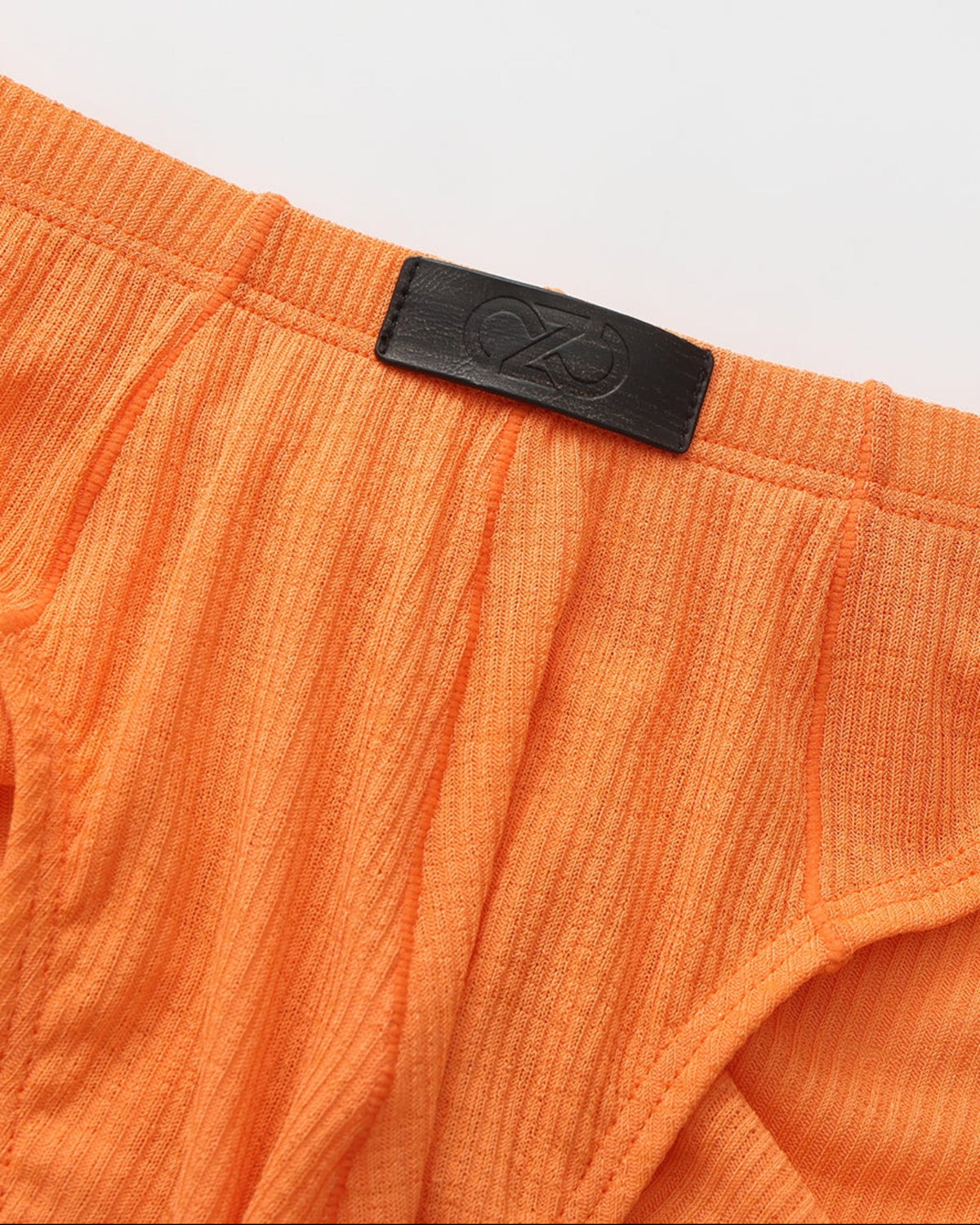 BSZN Crystal Veil V-Sculpt Brief — Orange front logo patch detail.