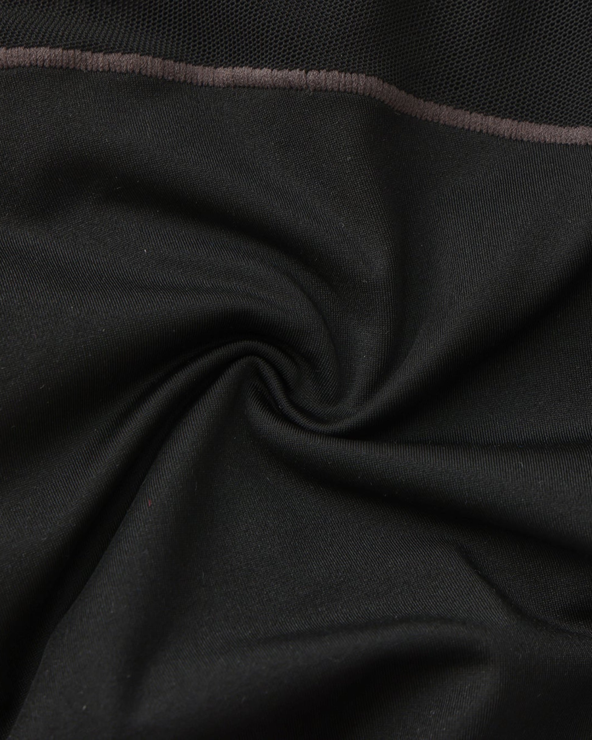 Close-up of the black stretch fabric and grey contrast stitching