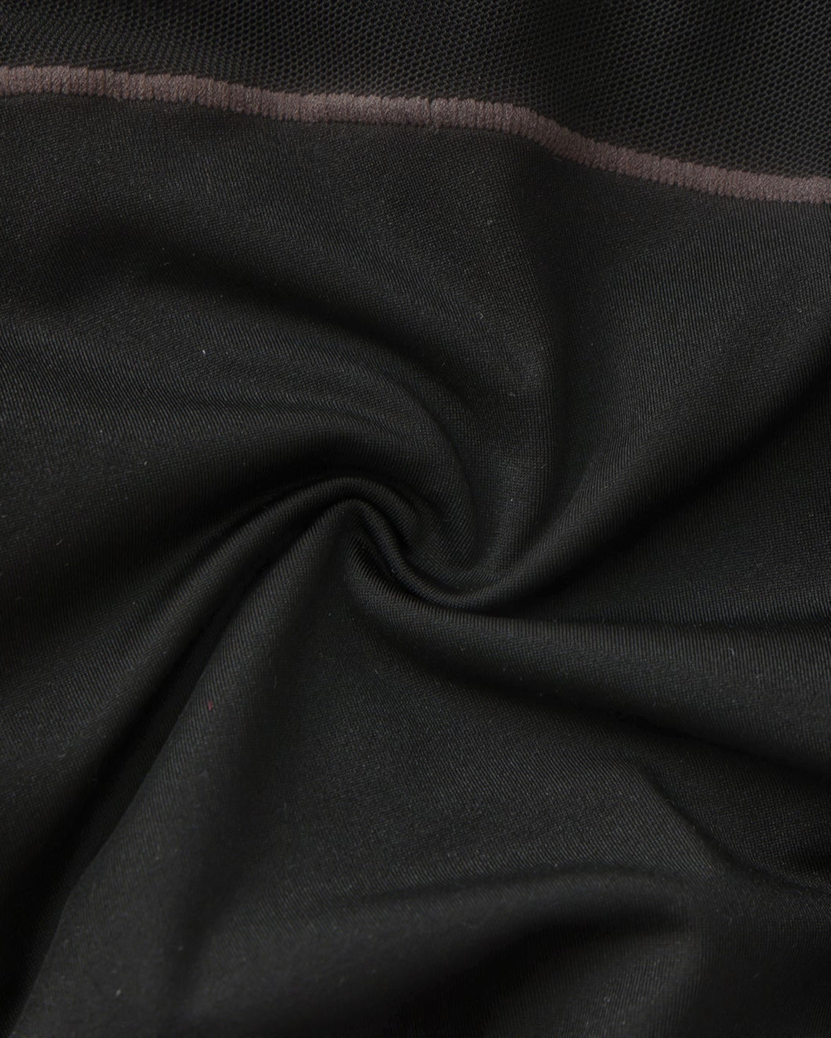 Close-up of the black stretch fabric and grey contrast stitching