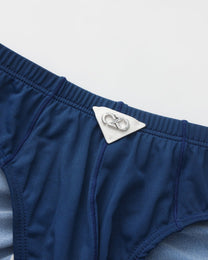 Close-up of the triangular metal BSZN badge and navy waistband