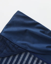 Close-up of the lustrous navy waistband above the stripe mesh