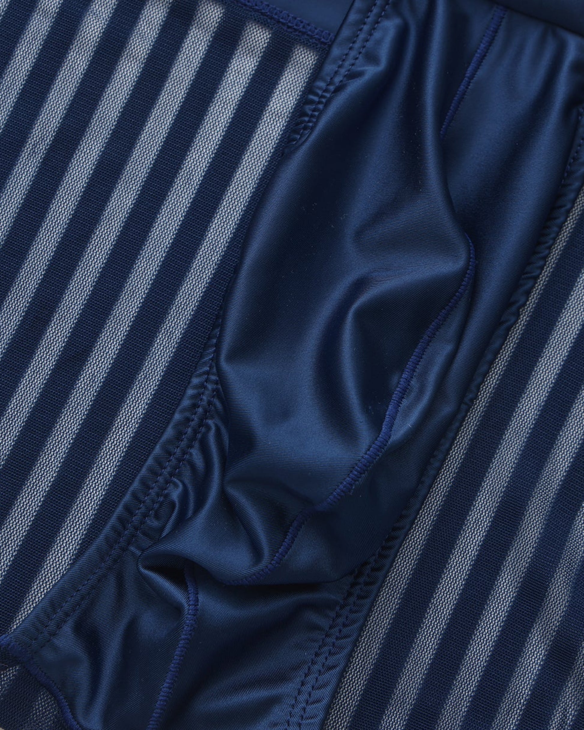 Close-up of the gathered pouch edge beside the vertical mesh stripes