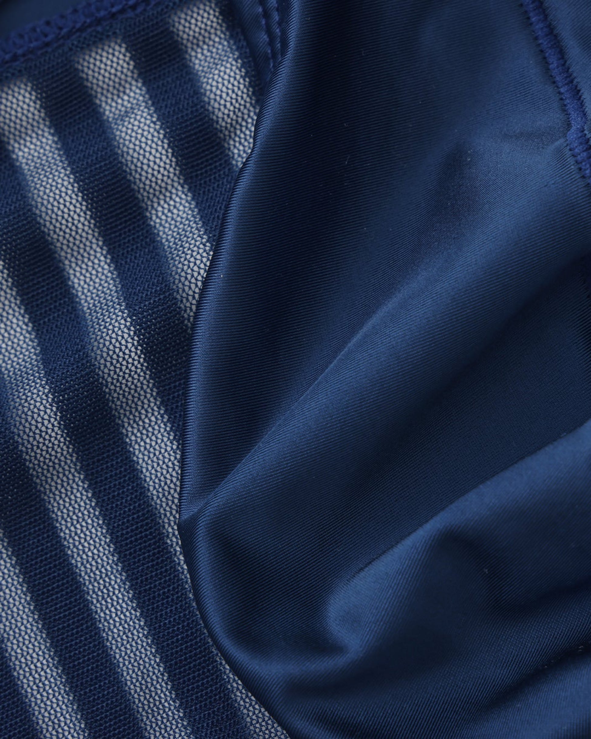 Close-up of the sheer stripe mesh meeting the smooth navy pouch panel