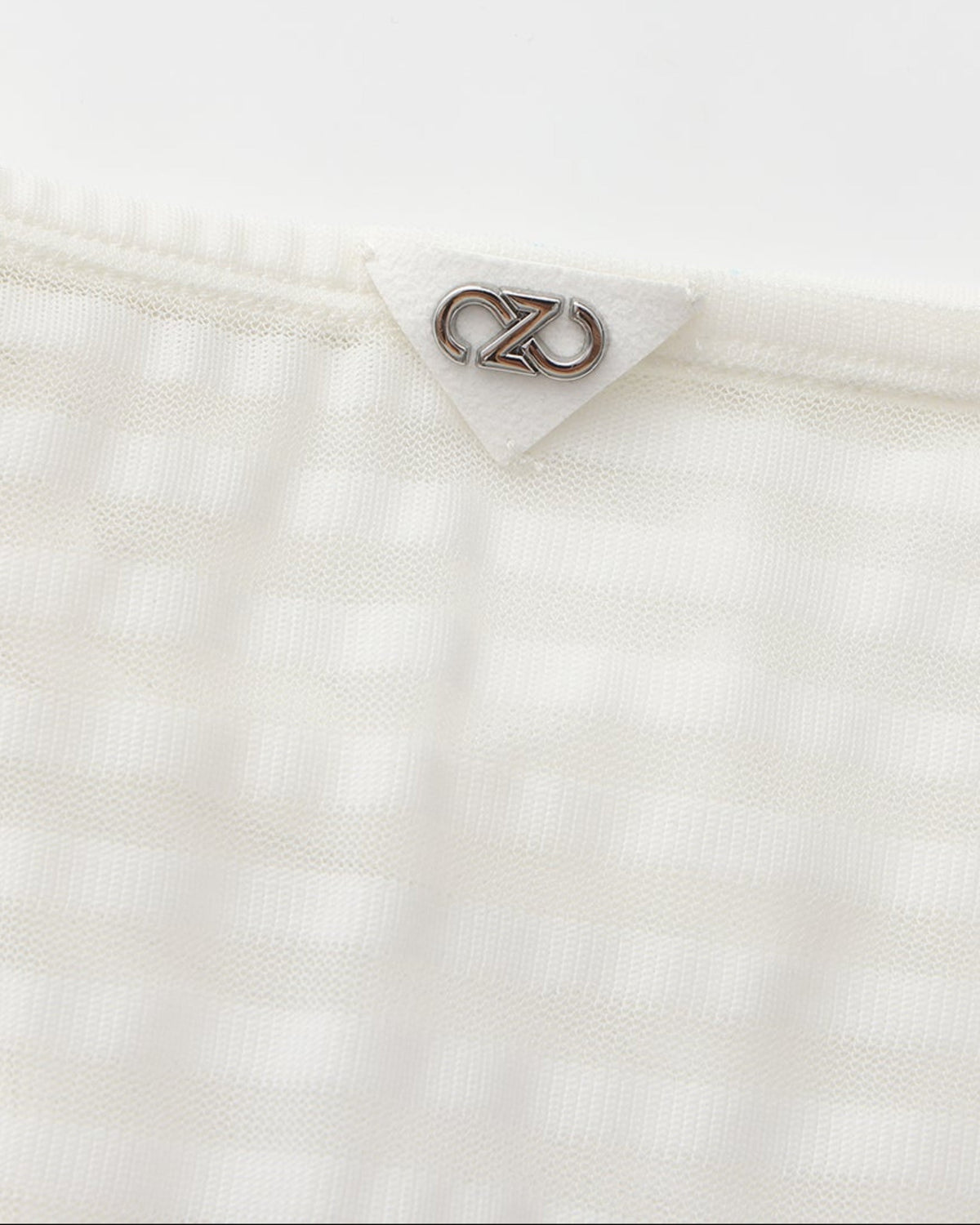 Close-up of the silver BSZN logo at the center rear waistband