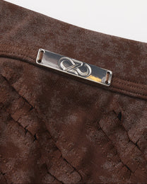Close-up of the silver-tone BSZN plaque and diagonal cutouts on the brown trunk