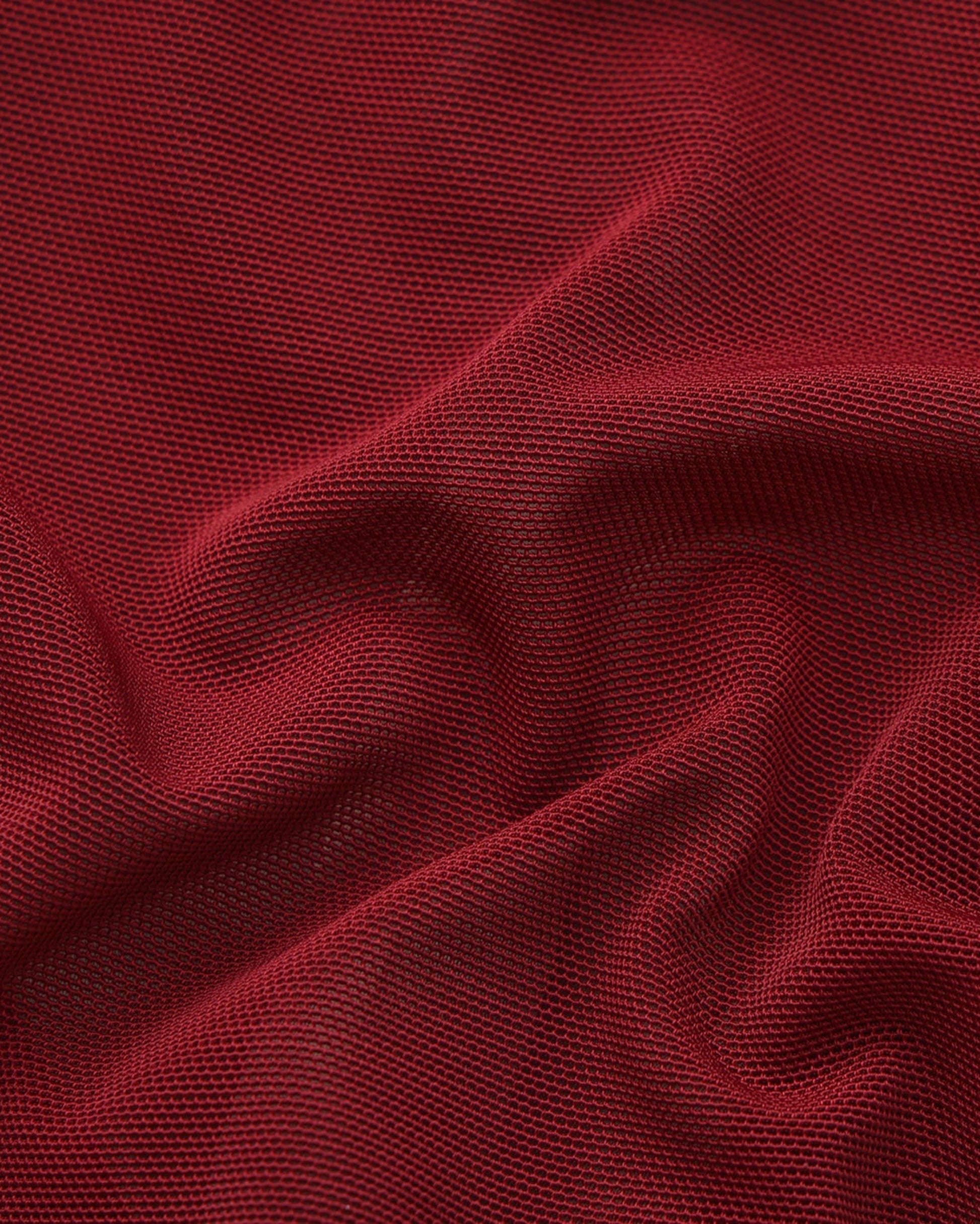 Close-up of the gathered deep red fine-mesh fabric