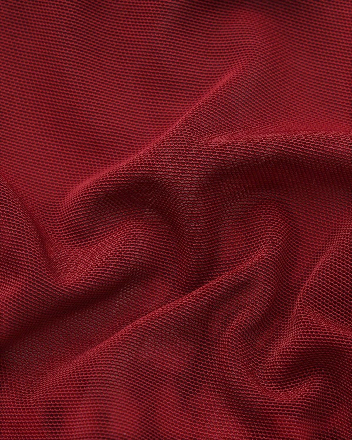Close-up of the gathered deep red fine-mesh fabric
