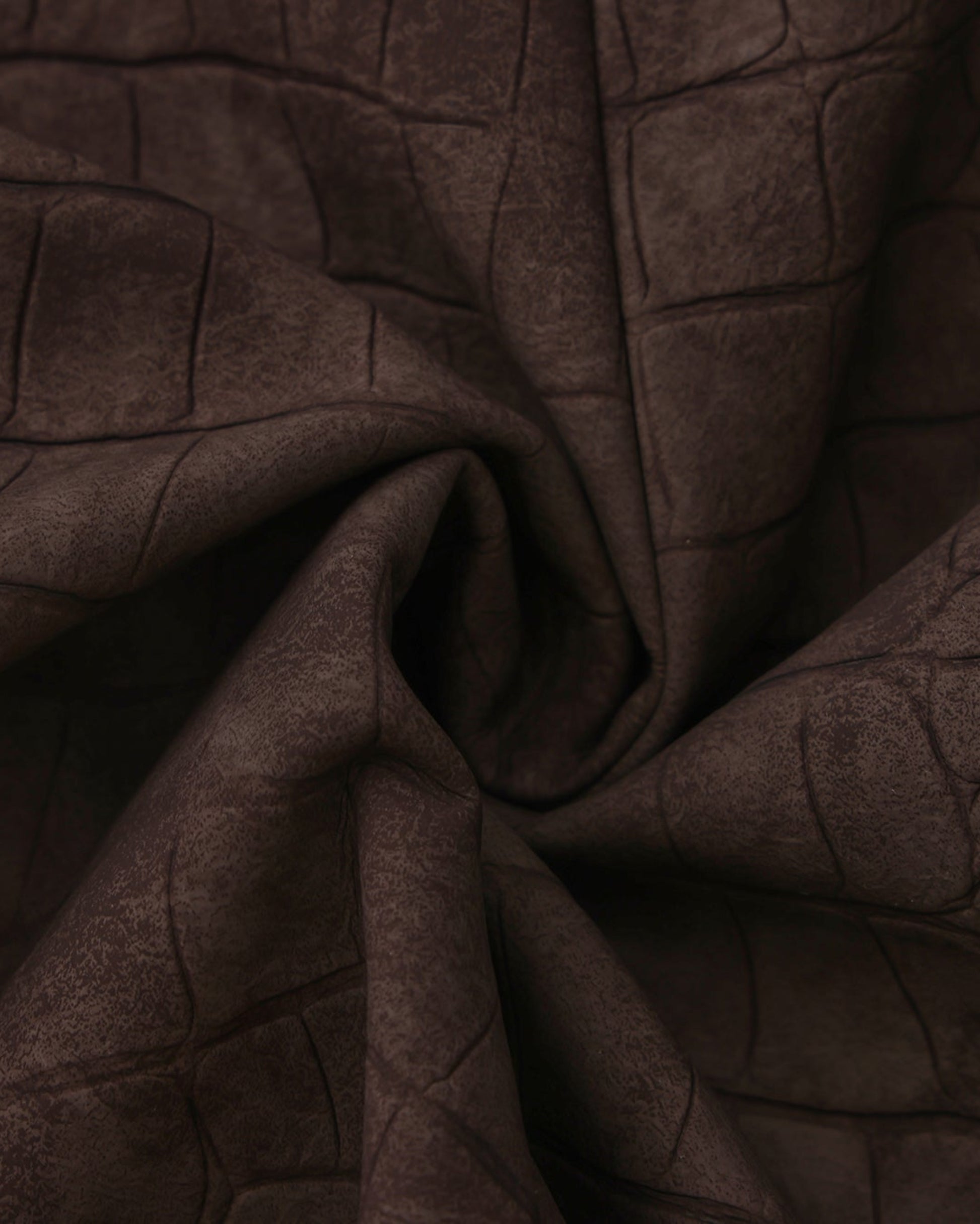 Close-up of the gathered brown reptile-embossed viscose texture