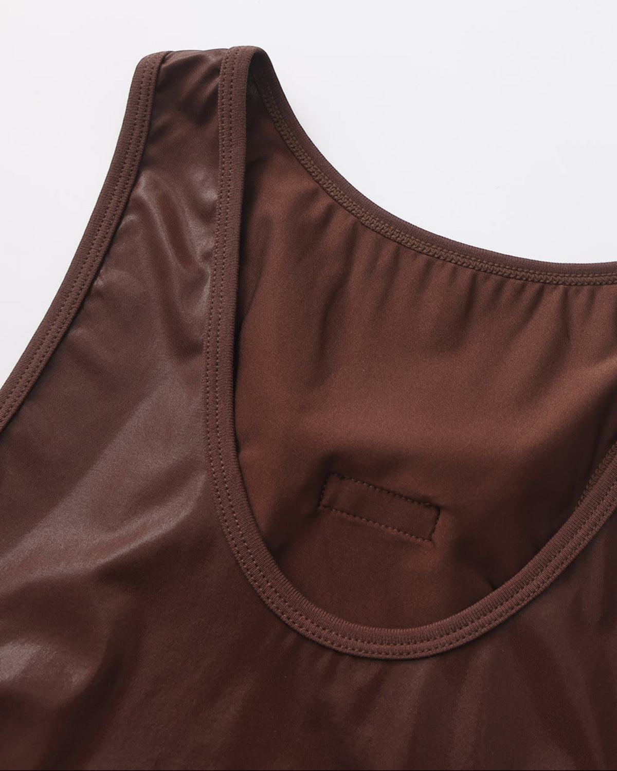 Close-up of the bound scoop neckline and stitched slot on the brown BSZN tank