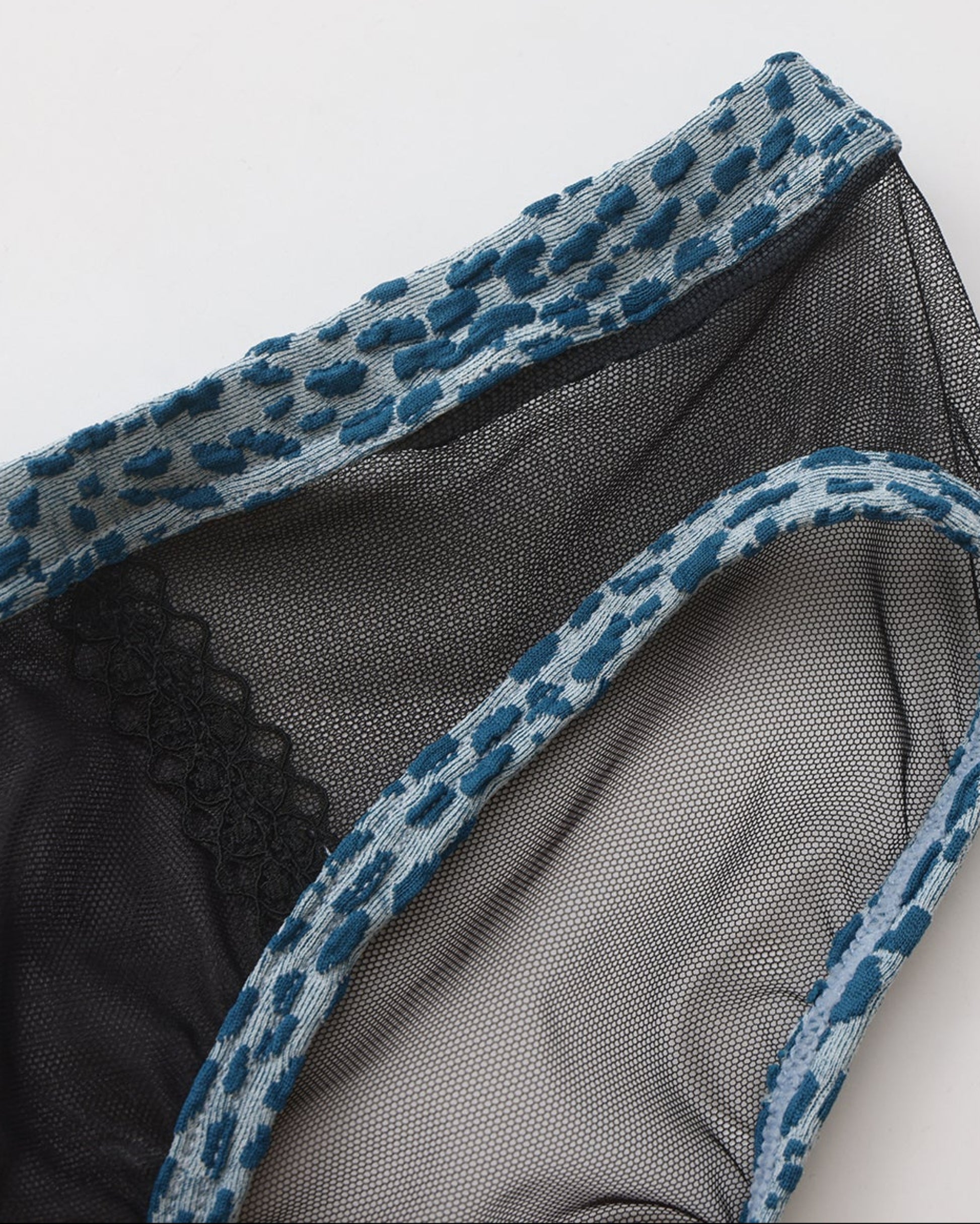 Close-up of blue animal-print binding and sheer black mesh