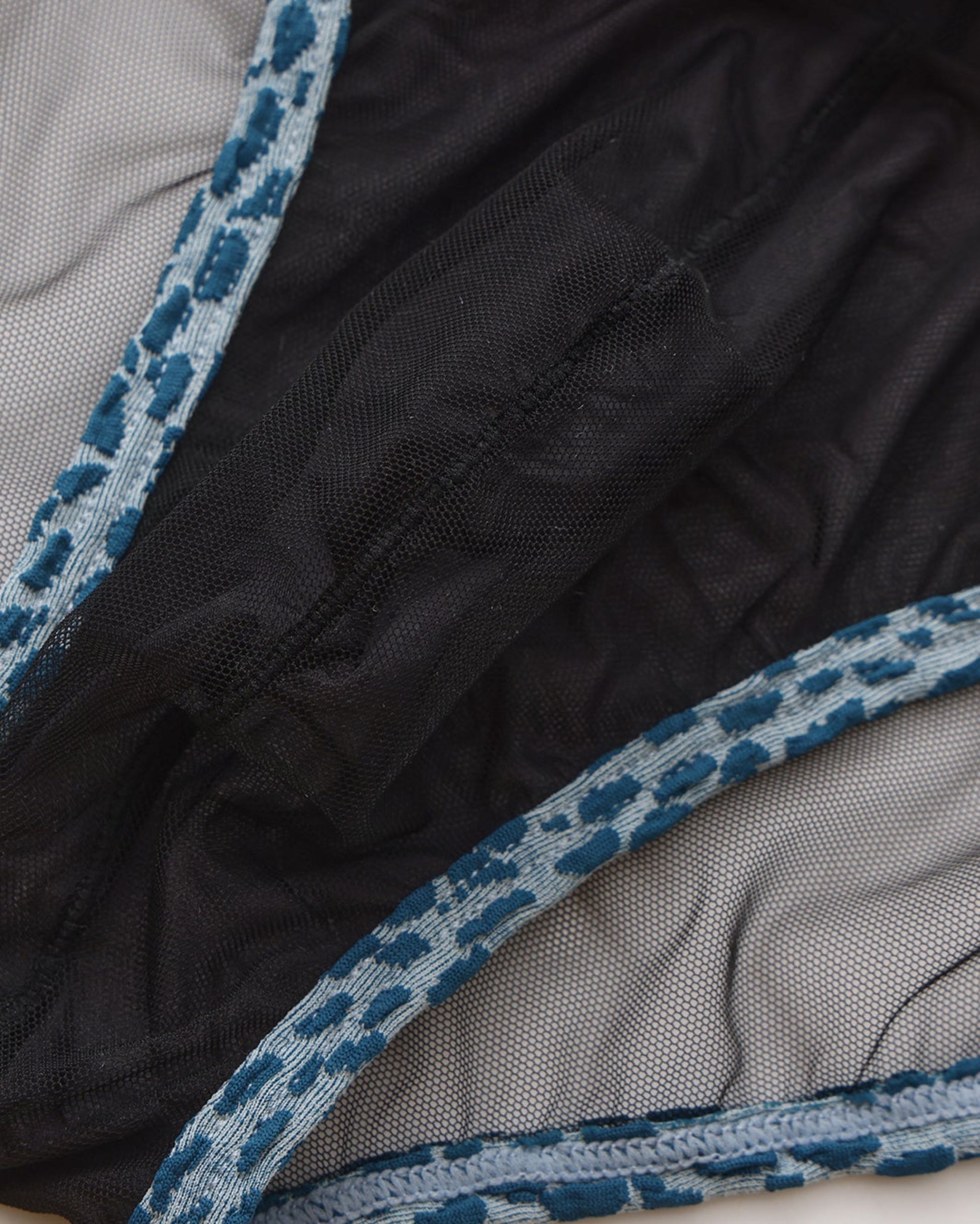 Close-up of mesh pouch lining and blue animal-print binding