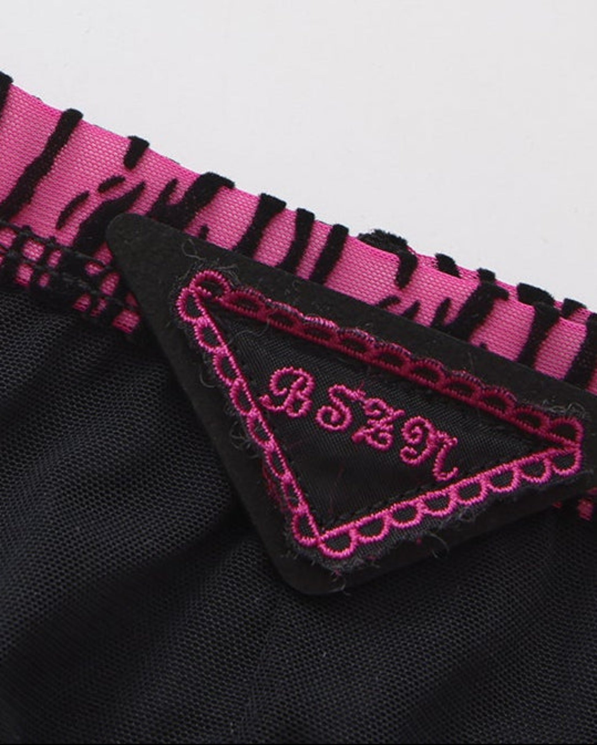 Close-up of the BSZN triangle badge with pink embroidery