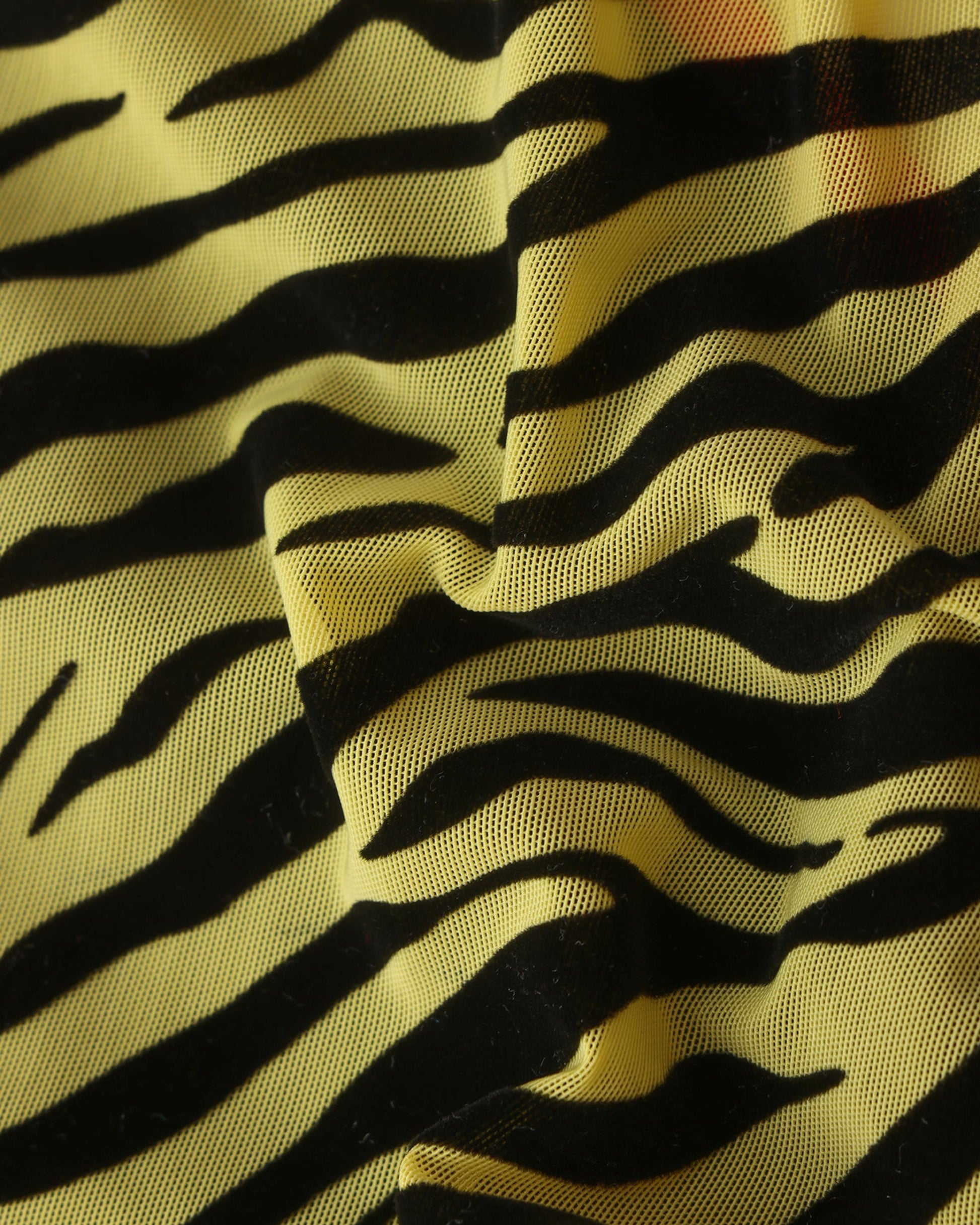 Close-up of flocked black animal print on yellow mesh