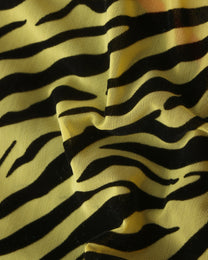Close-up of flocked black animal print on yellow mesh