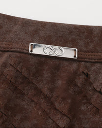 Close-up of the waistband plaque and front-cutout construction on the brown BSZN trunk