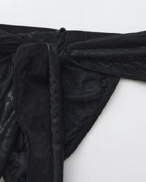 BSZN Draped scarf ties over patterned lace, close-up.