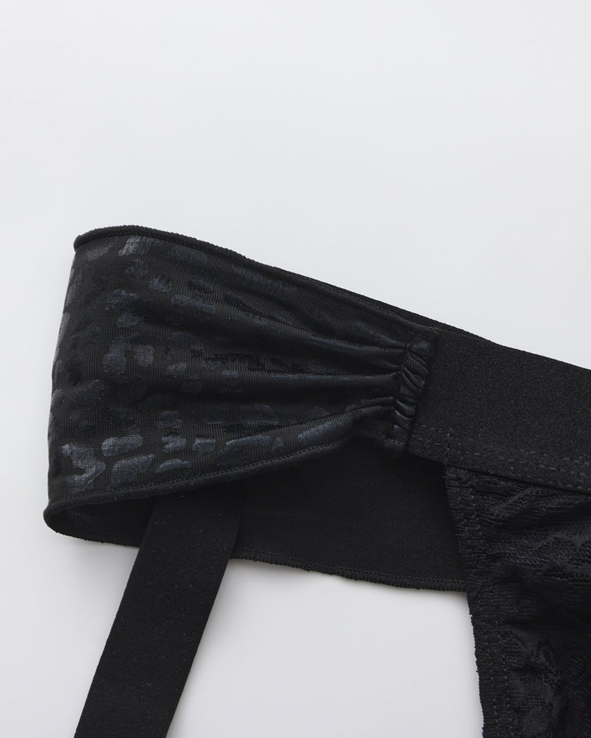 BSZN Glossy scarf fabric and elastic strap junction, close-up.