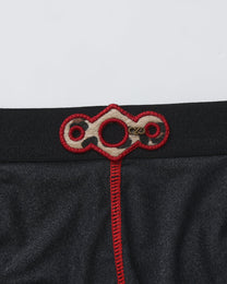 BSZN Spiderweb Heart Cutout Brief — Metal emblem and red embroidery close-up.