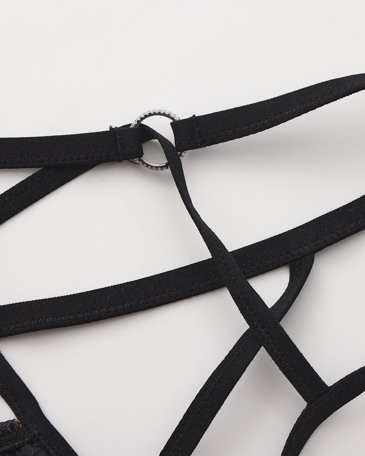 Close-up of the silver-tone ring and black strap junction on the BSZN cage thong
