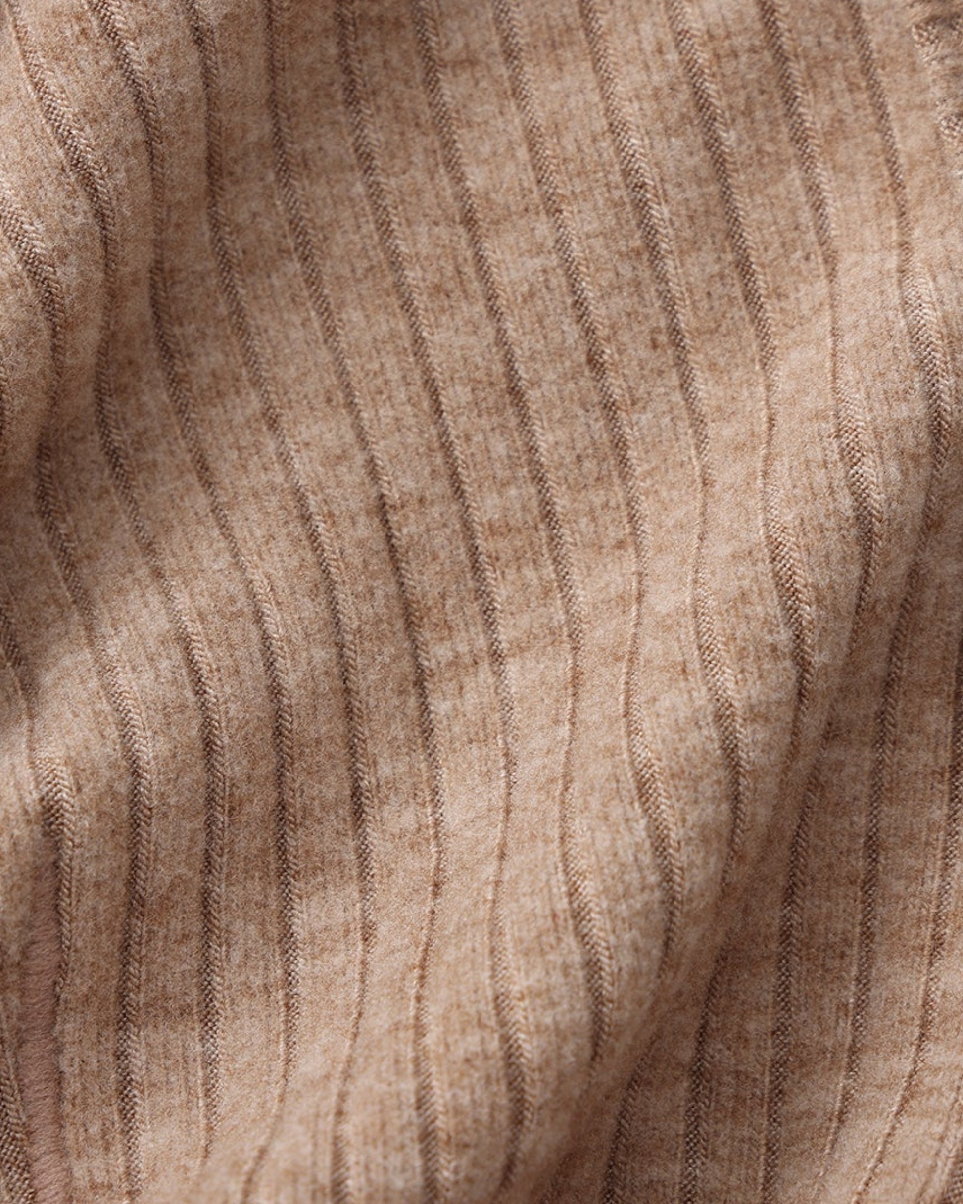 Close-up of the brown ribbed stretch fabric and seam texture