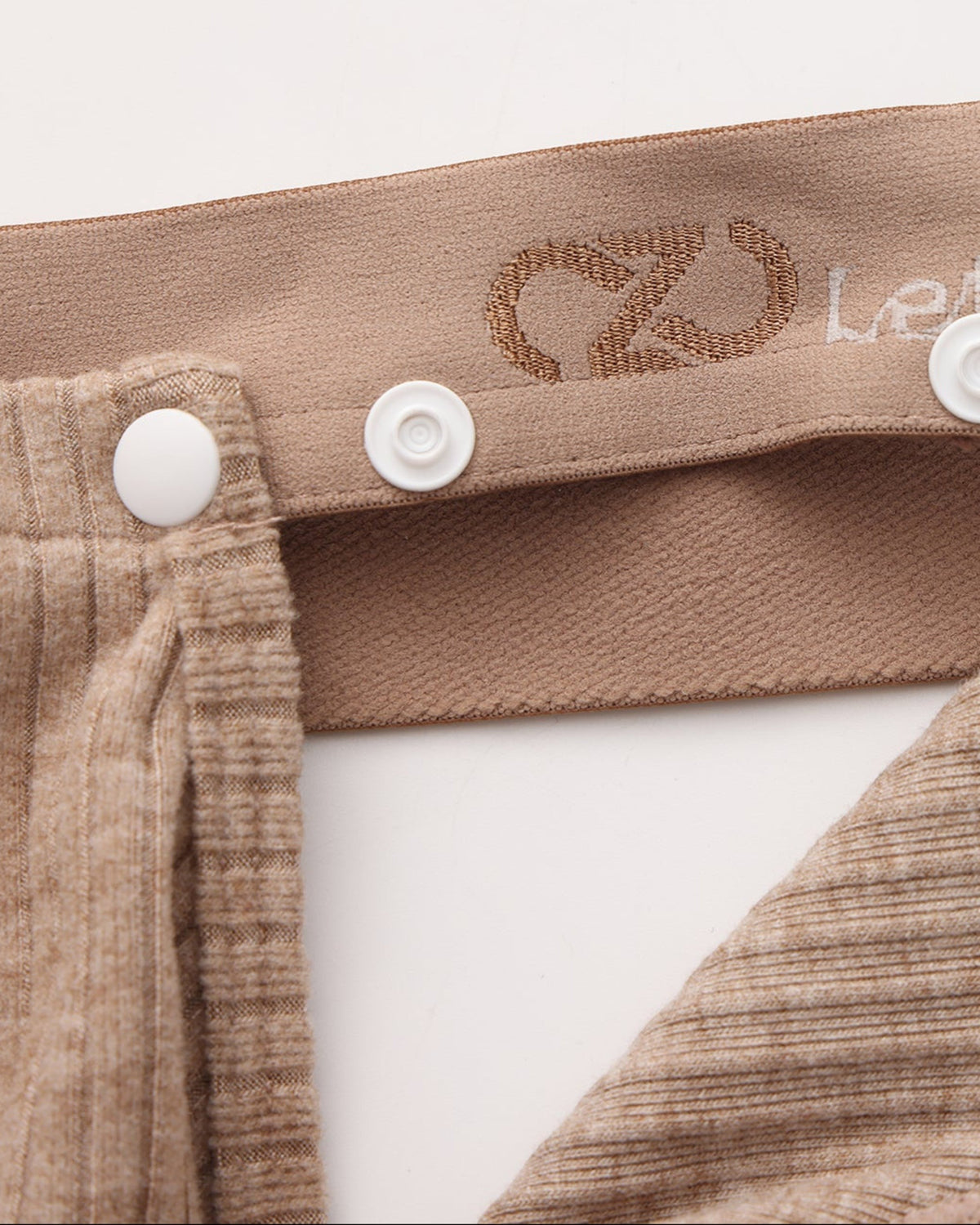 Close-up of the brown snap connection and BSZN logo waistband