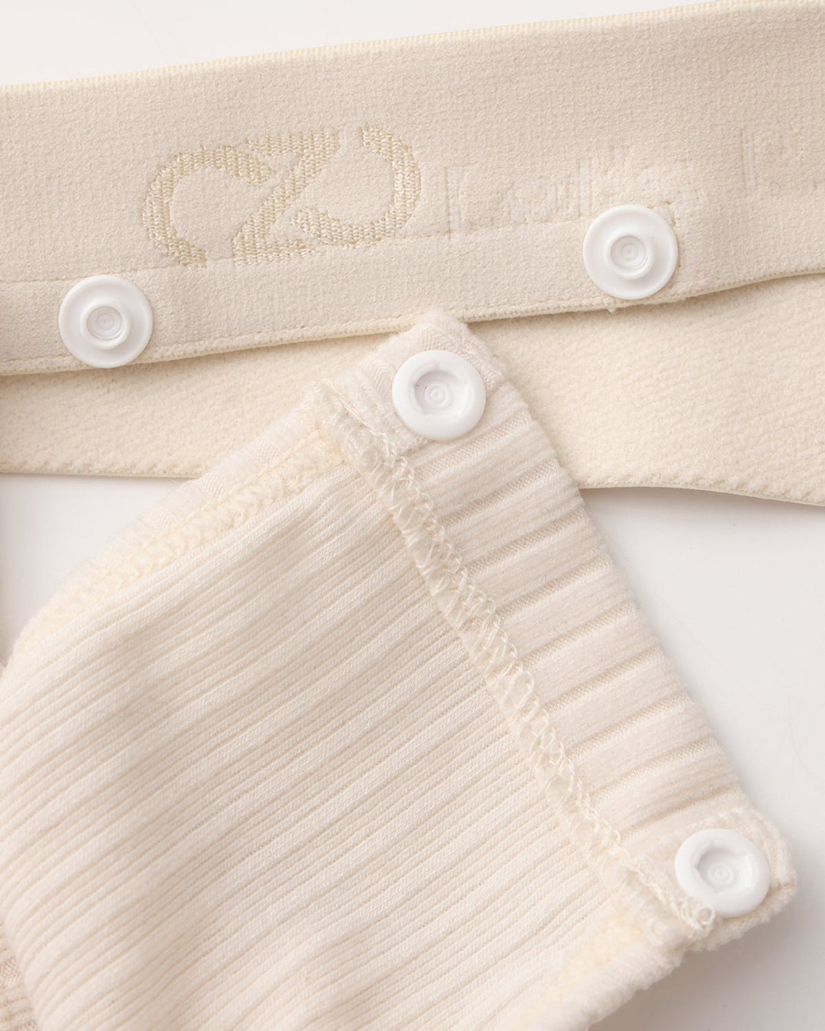 Close-up of the white snap connection and BSZN logo waistband