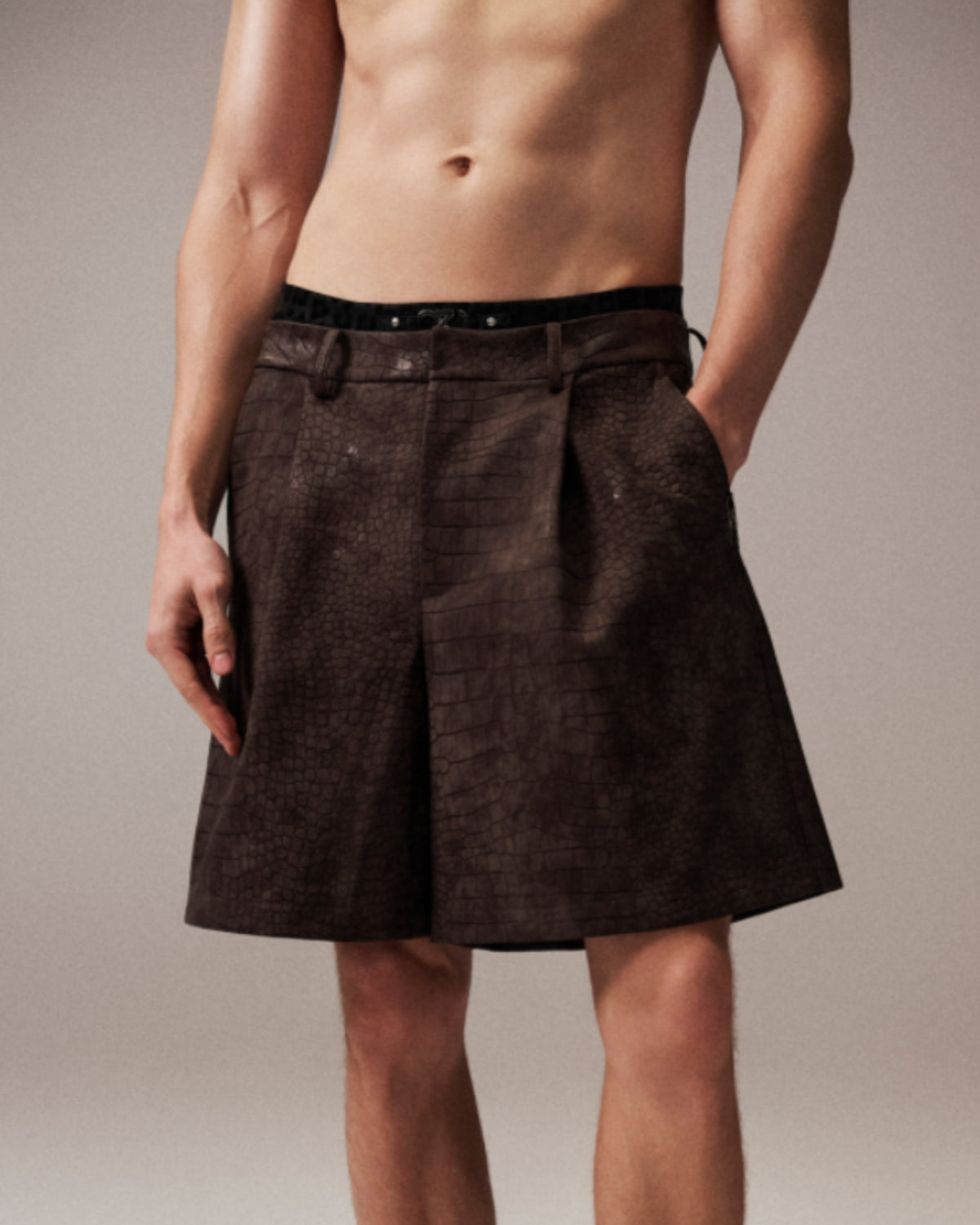 Model wearing the brown BSZN reptile-embossed tailored shorts, front three-quarter view