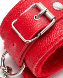 Close-up of the red wrist-cuff buckle, rivet, coated texture and plush lining