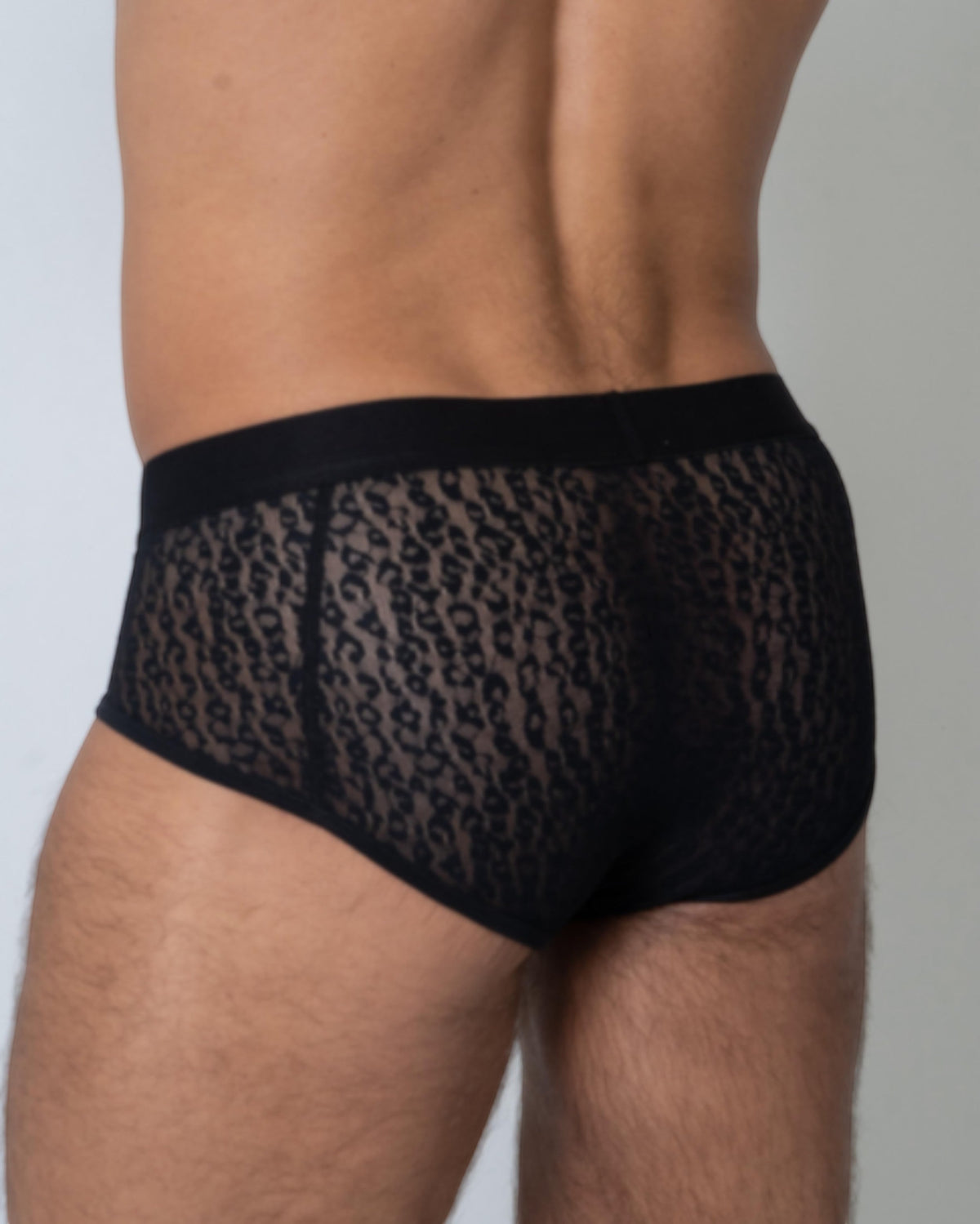 Model wearing the black BSZN Sheer Leopard Mesh Brief, full-coverage rear view