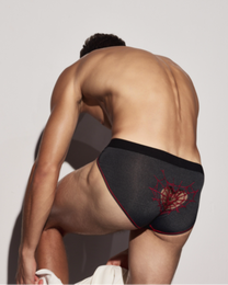 BSZN Spiderweb Heart Cutout Brief — Black rear detail on seated model.